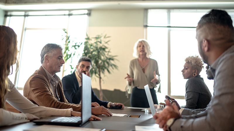 A group of employees sitting at a conference room table