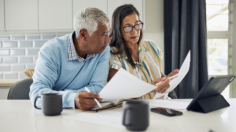 A couple looking at paperwork in their kitchen