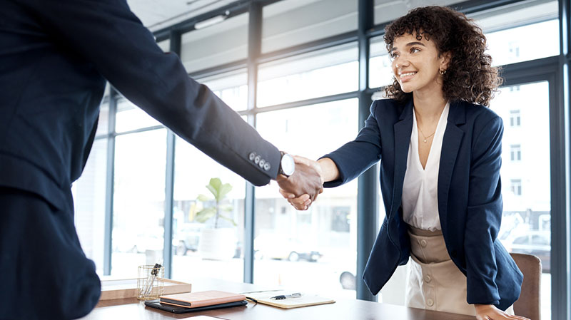 Two office workers shaking hands