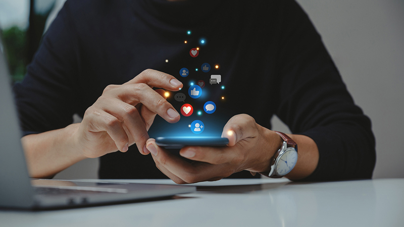 Hands holding a phone with icons