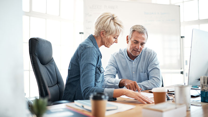 A man and woman sitting at a desk